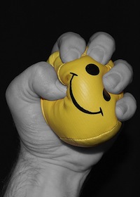 Hand squeezing a yellow stress ball