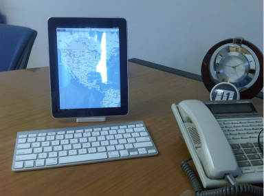 iPad and wireless keyboard on an office desk, with an office phone