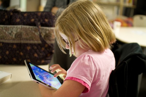 Child using an ipad, photo by Devon Christopher Adams