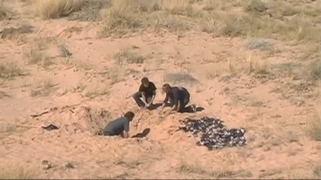 Men digging up E.T. games in the desert