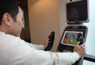 Kai Huang plays exercise game on a stationary bike.