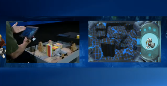 A demonstration game: an Intel employee points a tablet at a sandbox (left) and the tablet renders the sandbox in 3D (right).