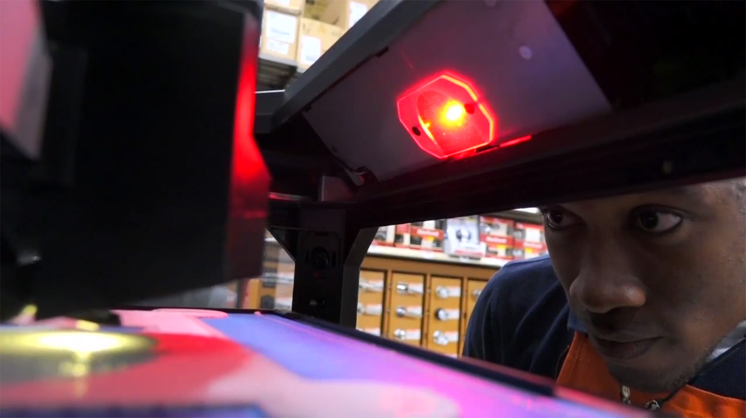 A Home Depot employee looks inside a MakerBot 3D printer.