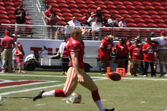 A 49ers kicker warms up on the field.