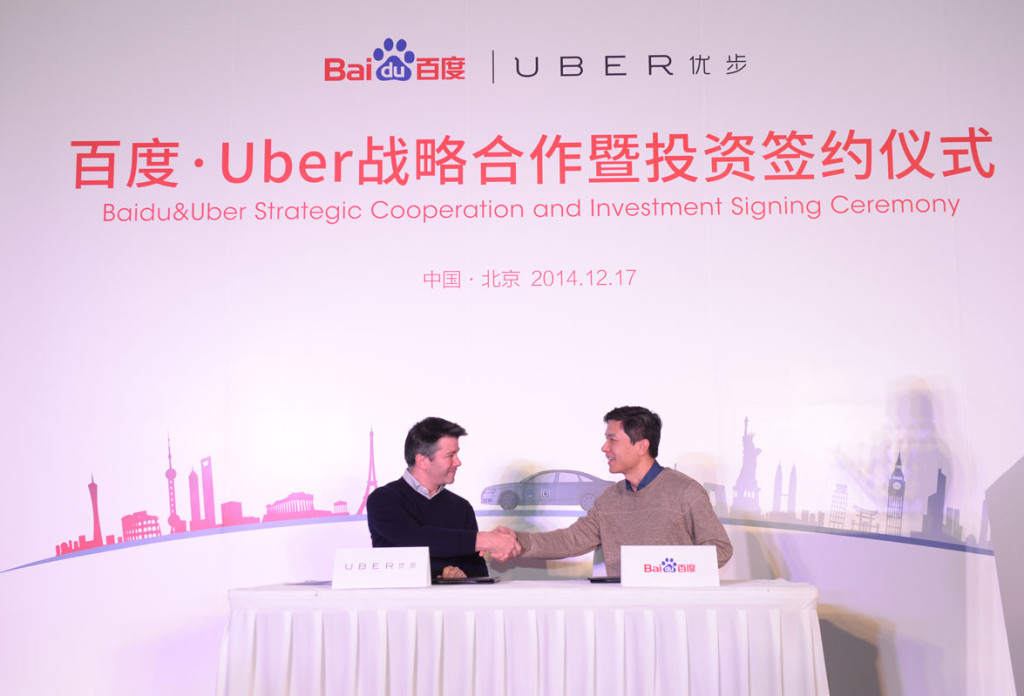 Uber CEO Travis Kalanick (left) shakes hands with Baidu chairman and CEO Robin Li.