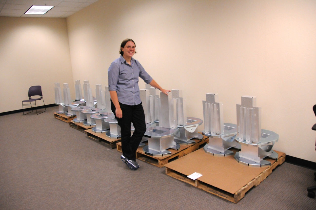 Fetch Robotics CEO Melonee Wise, standing in front a a group of sheet-metal robot bases.