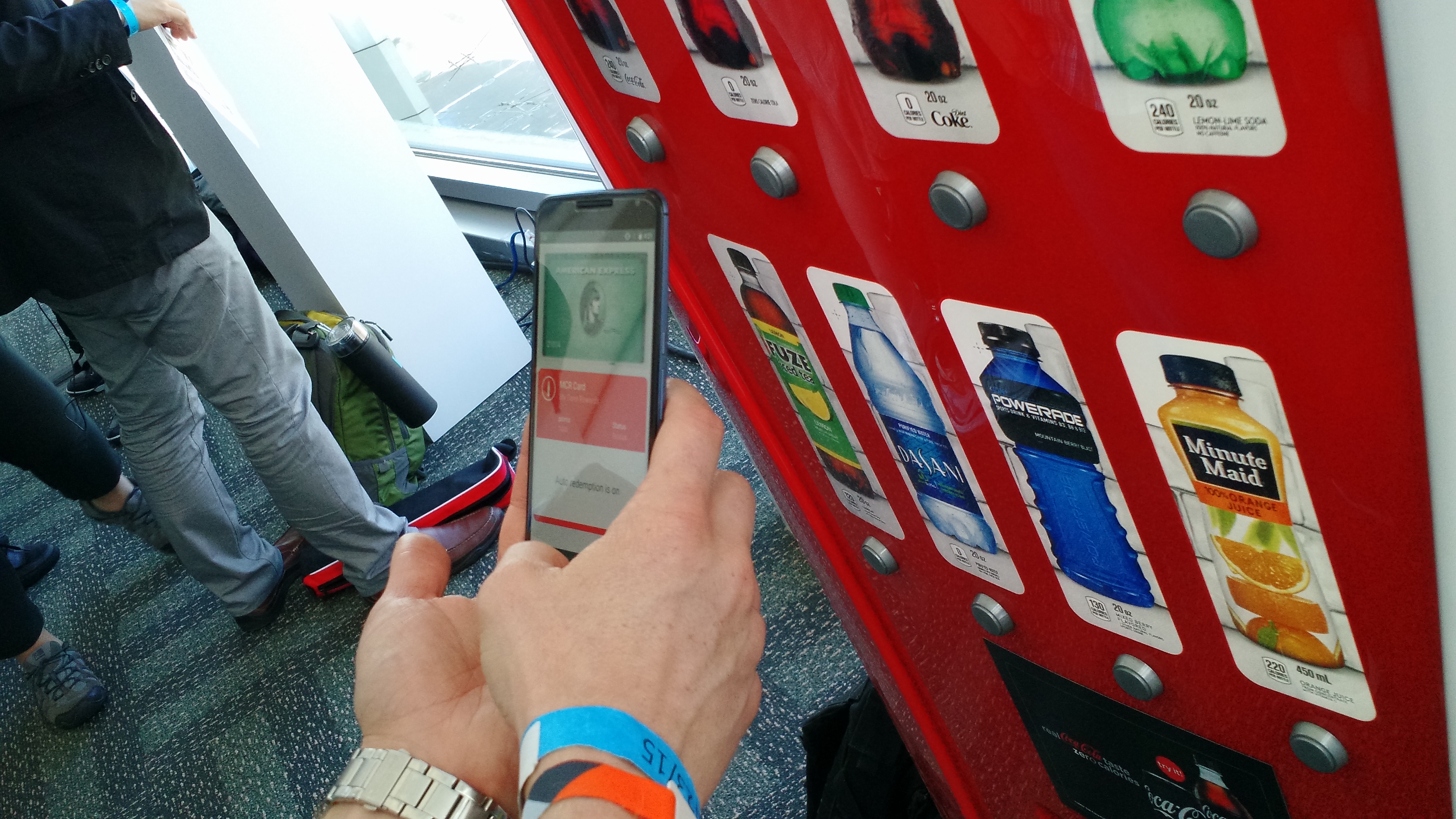 Android Pay being demonstrated on a Coke machine. It's using an American Express card and a Coca-Cola loyalty program.