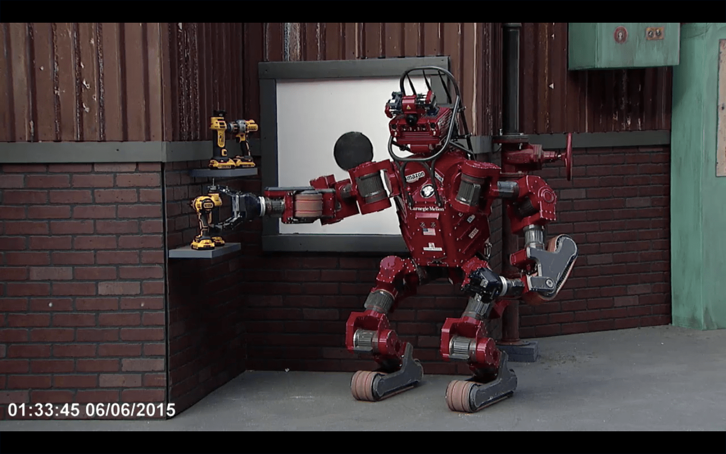 Tartan Rescue's CHIMP robot picks up a drill for the wall task at the 2015 DARPA Robotics Challenge in Pomona, Calif., on June 4.