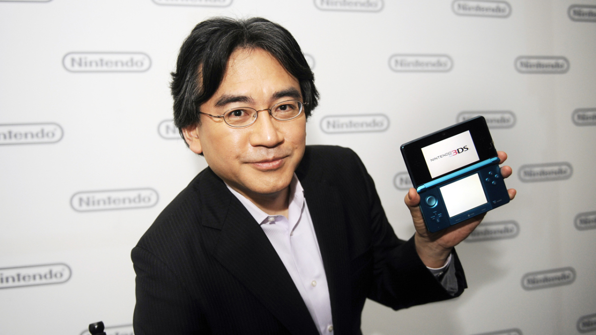 Iwata holding a Nintendo 3DS. 