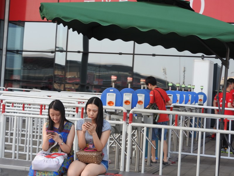 Attendees take a break on their mobile phones at ChinaJoy 2015.