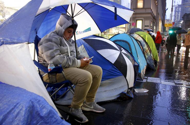 Marcus Barsum waits outside the Apple store in central Sydney Thursday. Reuters/David Gray
