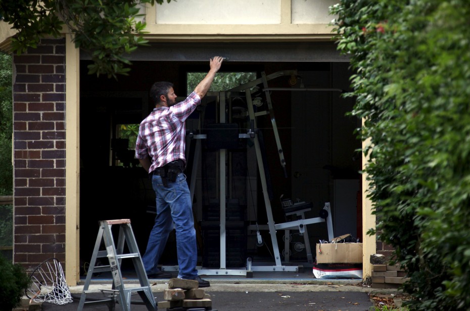 An Australian Federal Police officer closes the door of the garage after searching the home of probable creator of cryptocurrency bitcoin Craig Steven Wright in Sydney's north shore December 9, 2015