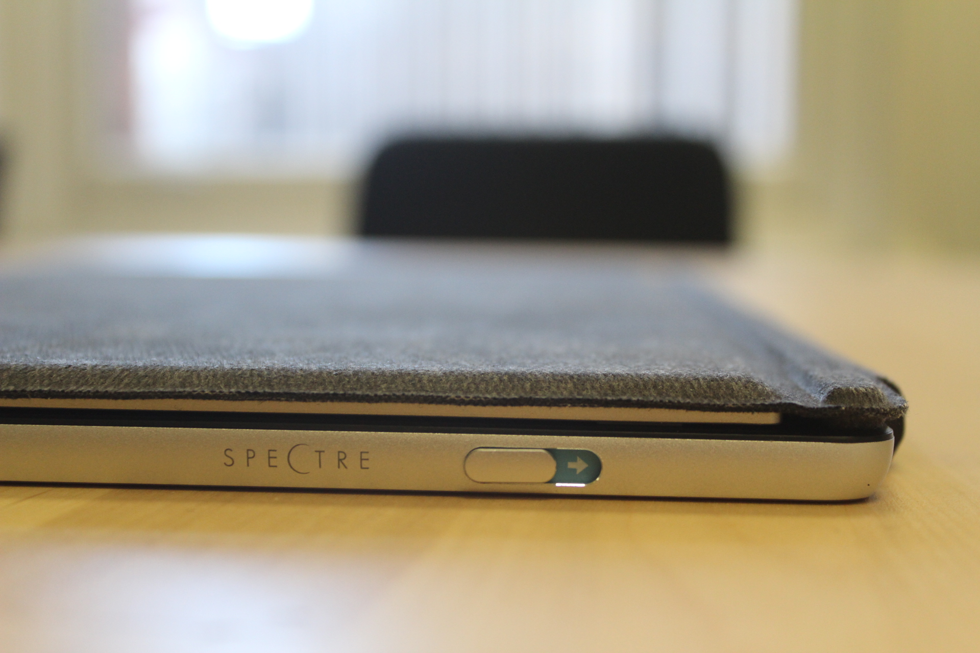 The button you need to slide in order to push out the kickstand bar on the HP Spectre x2.
