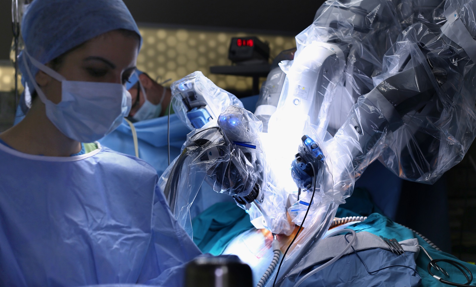 A robot performs surgery while a doctor overseas the procedure.