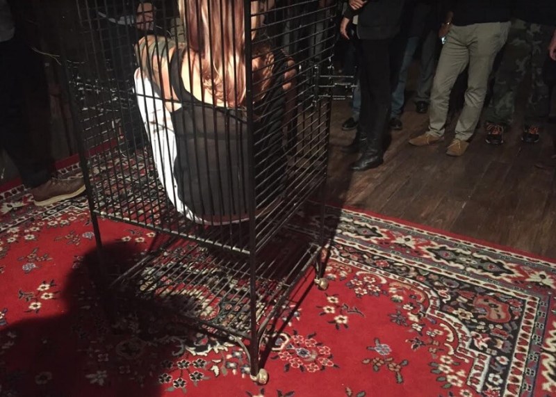 A woman tries out a bondage cage at a tour of Kink.com's The Armory.