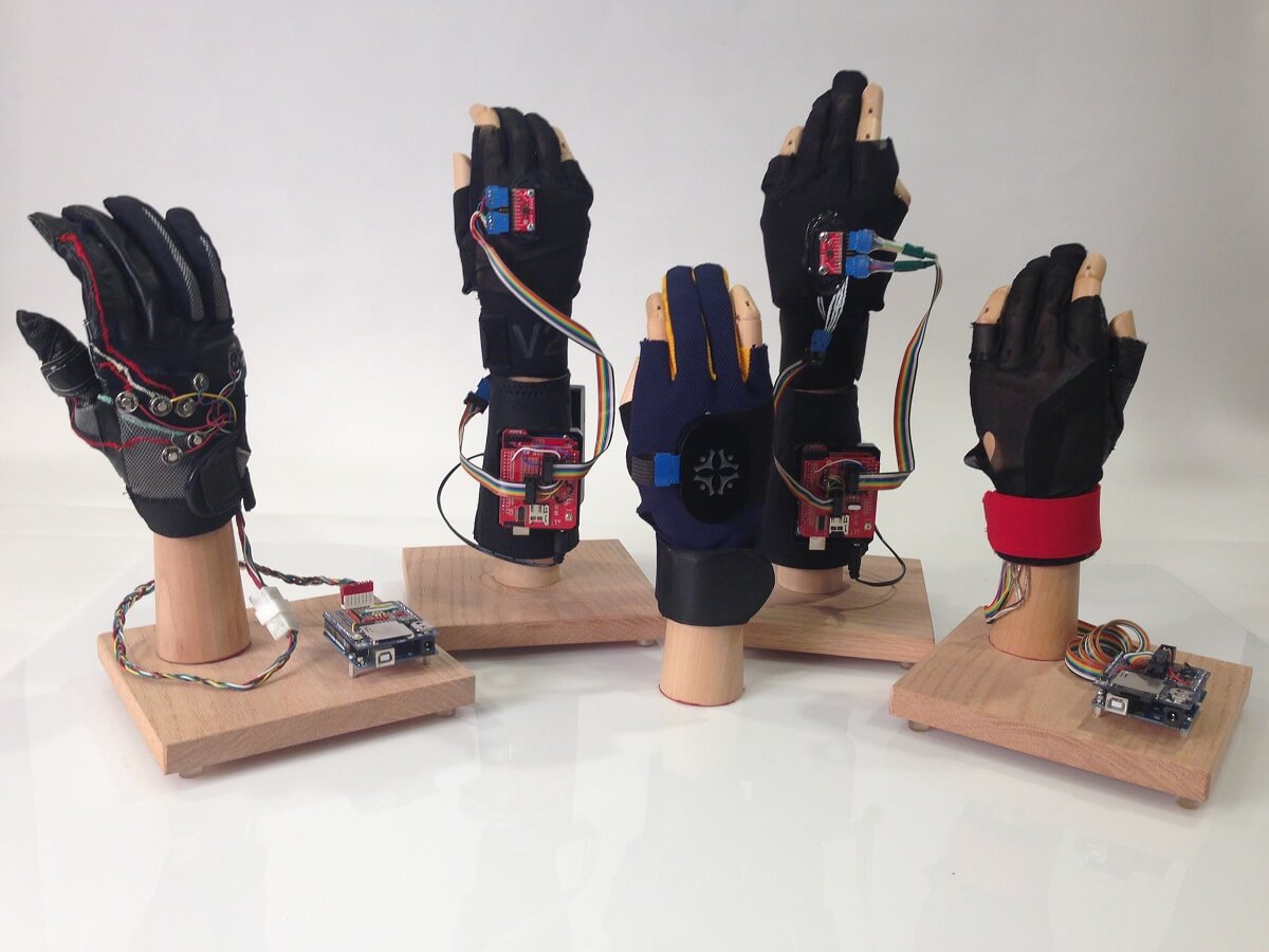 Proof of concept glove (far left) Wired prototypes using arduino (back row) Wireless Bluetooth Glove used on A.mericas Greatest Makers (front center)