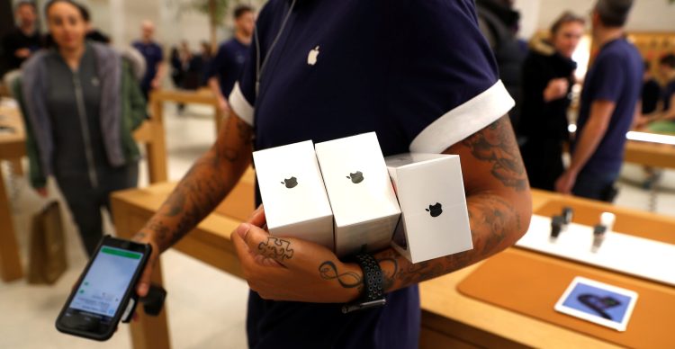 An Apple Store staff shows Apple's new iPhones X after they go on sale at the Apple Store in Regents Street, London, Britain, November 3, 2017. 