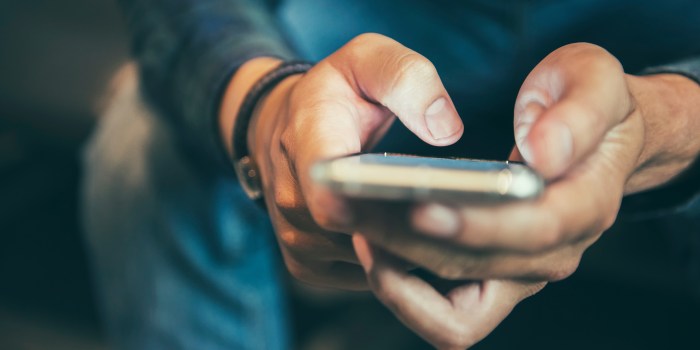 Midsection Of Man Using Mobile Phone