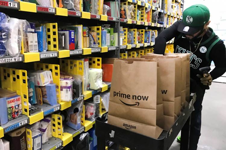 An employee collects items ordered by Amazon.com customers through the company's two-hour delivery service Prime Now in a warehouse in San Francisco, December 20, 2017.