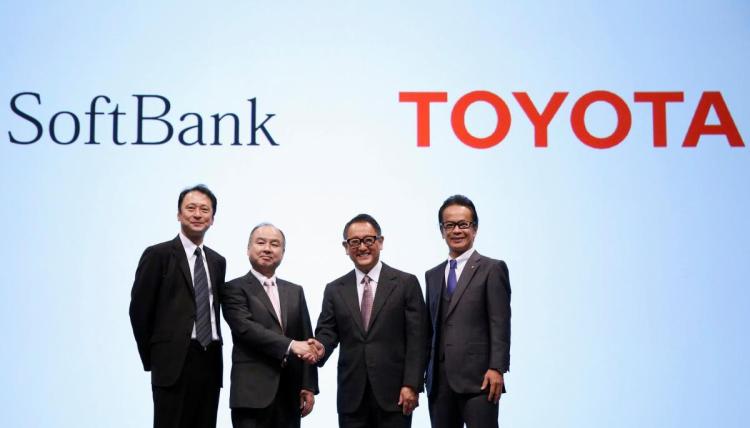 Toyota President Akio Toyoda and Executive Vice President Shigeki Tomoyama pose for a photograph with SoftBank Chairman and CEO Masayoshi Son and SoftBank Representative Director and CTO Junichi Miyakawa during joint news conference in Tokyo.