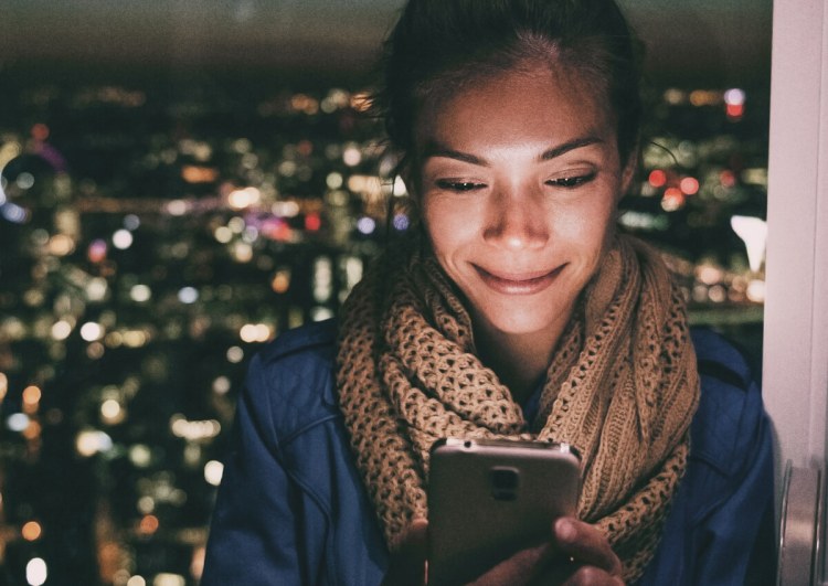 Person smiling looking at cellphone
