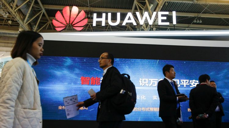 People walk past the stall of the telecommunications equipment maker Huawei Technologies at the Security China 2018 exhibition on public safety and security in Beijing, China October 23, 2018.