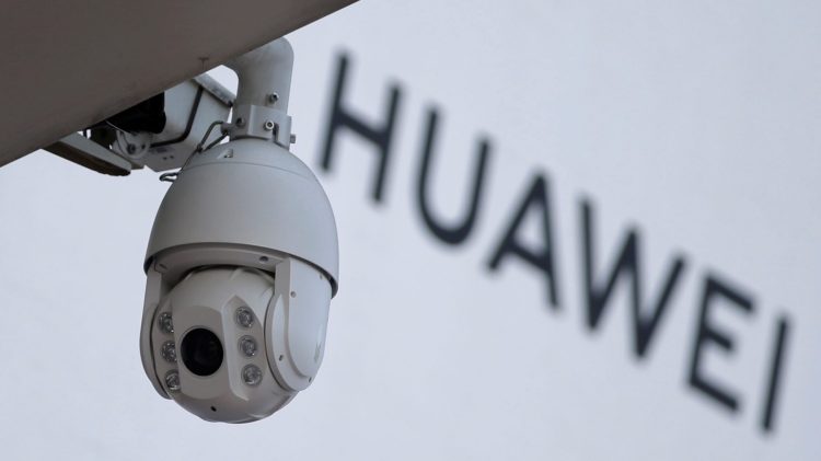 A surveillance camera is seen next to a sign of Huawei outside a shopping mall in Beijing, China January 29, 2019.