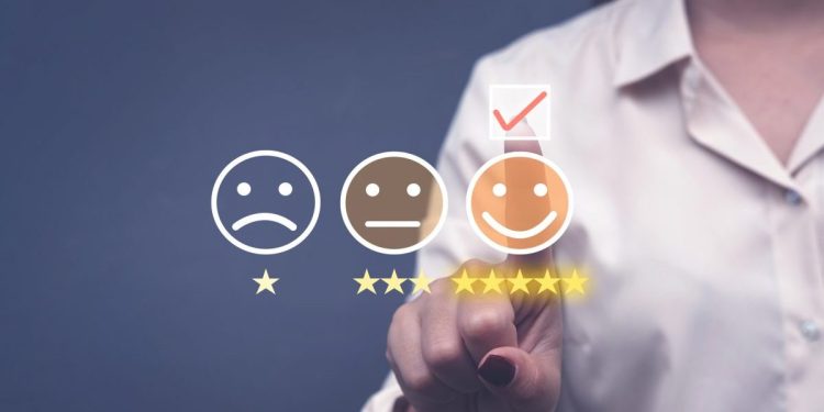 Customer experience and data concept image with person selecting smiling face five star icon