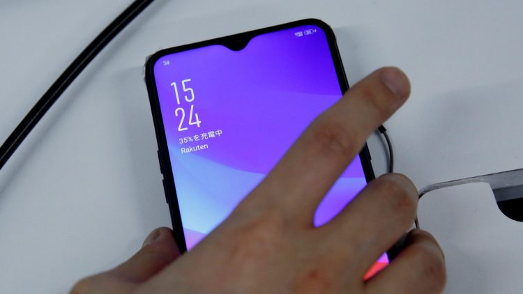 A staffer holds a smart phone being tested for Rakuten's mobile network at its facility in Tokyo, Japan, February 20, 2019.