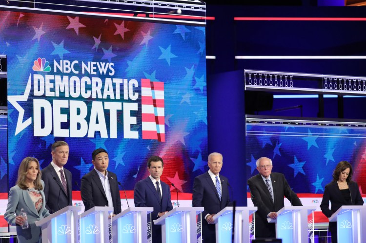 MIAMI, FLORIDA - JUNE 27: Democratic presidential candidates (L-R) Marianne Williamson, former Colorado governor John Hickenlooper, former tech executive Andrew Yang, South Bend, Indiana Mayor Pete Buttigieg, former Vice President Joe Biden, Sen. Bernie Sanders (I-VT), and Sen. Kamala Harris (D-CA) take part in the second night of the first Democratic presidential debate on June 27, 2019 in Miami, Florida.  A field of 20 Democratic presidential candidates was split into two groups of 10 for the first debate of the 2020 election, taking place over two nights at Knight Concert Hall of the Adrienne Arsht Center for the Performing Arts of Miami-Dade County, hosted by NBC News, MSNBC, and Telemundo.