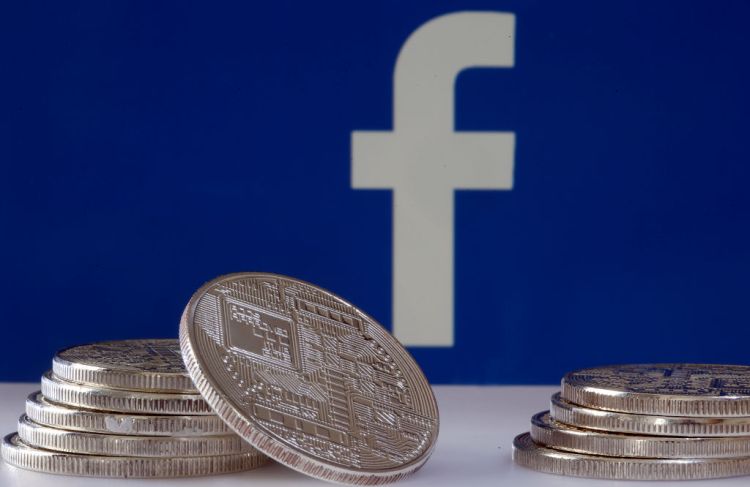 PARIS, FRANCE - JUNE 18: In this photo illustration, a visual representation of a digital cryptocurrency coin sits on display in front of a Facebook logo on June 17, 2019 in Paris, France. Facebook will announce Tuesday, June 18 the details of its cryptocurrency, called " Libra ". Like bitcoin, the best-known virtual currency, it will rely on blockchain technology. This universal currency must allow its users to buy products or services from the Facebook universe, which also owns Messenger, Instagram and WhatsApp. It will also be possible to transfer "Libras" between individuals. Several companies like Visa, MasterCard, PayPal and Uber have already joined the consortium created by Facebook. (Photo by Chesnot/Getty Images)