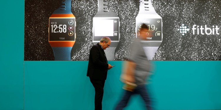 Visitors walk past an advertising billboard for Fitbit Ionic watches at the IFA Electronics Show in Berlin