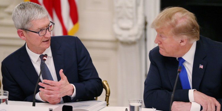 Apple CEO Tim Cook talks with U.S. President Donald Trump