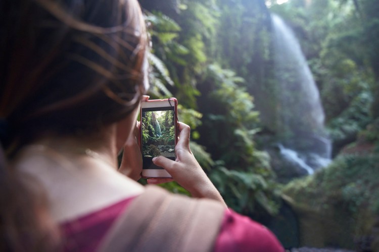 Person taking picture of beautiful landscape with mobile phone