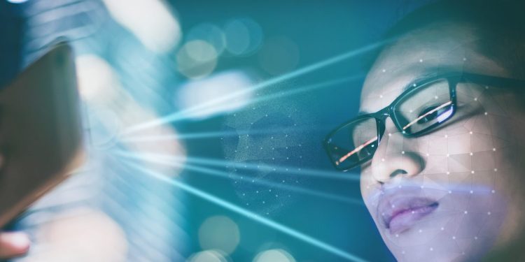 Businessman using using face recognition outdoors