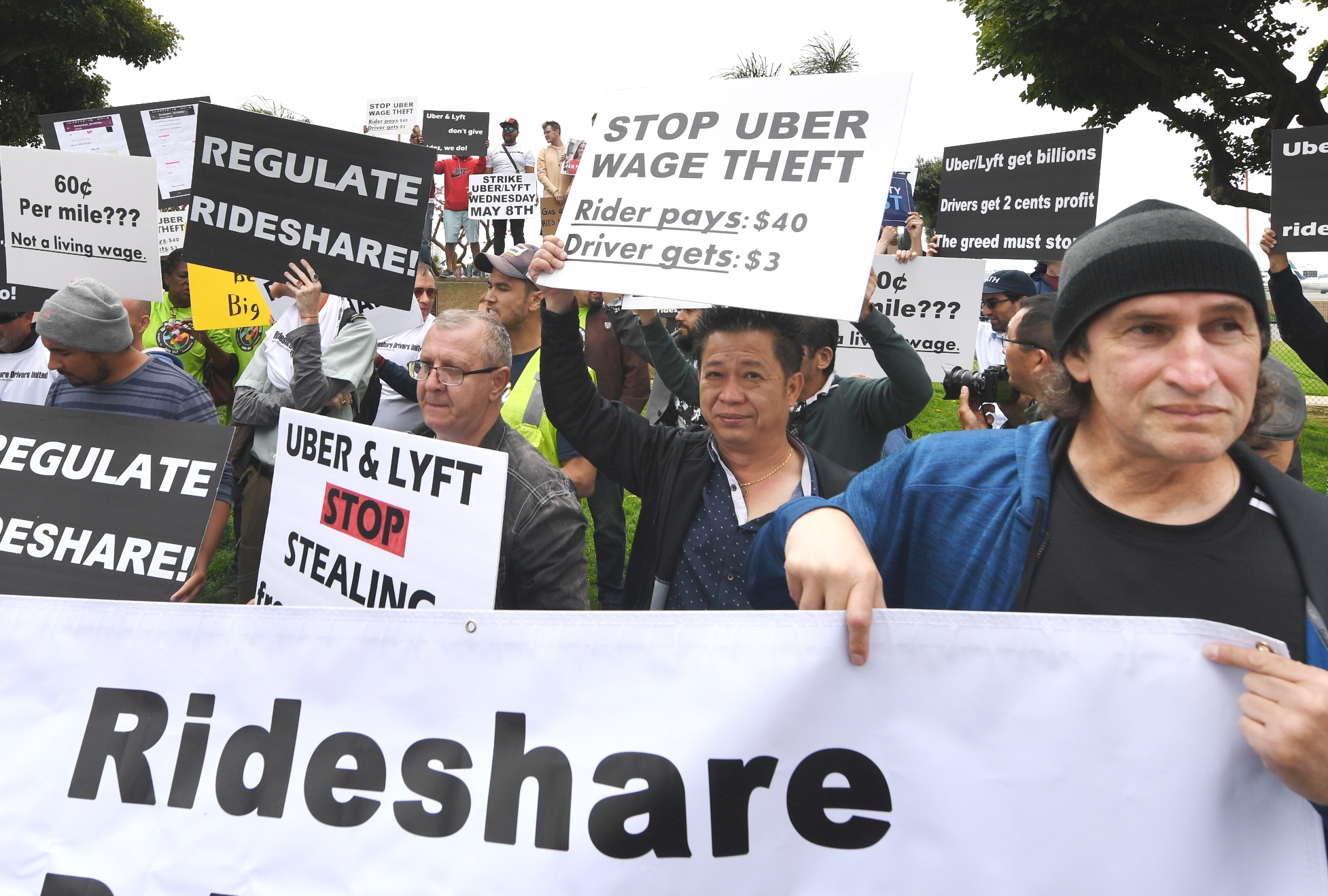 Rideshare drivers for Uber and Lyft stage a strike and protest at the LAX International Airport, over what they say are unfair wages in Los Angeles, California on May 8, 2019. - One of the early promises of the ride-hailing era ushered in by Uber and Lyft was that the new entrants would complement public transit, reduce car ownership and help alleviate congestion. But a new study on San Francisco has found the opposite may be in fact be true: far from reducing traffic, the companies increased delays by 40 percent as commuters ditched buses or walking for mobile-app summoned rides