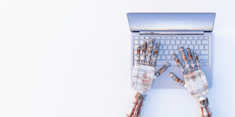 Robot hands typing on a laptop
