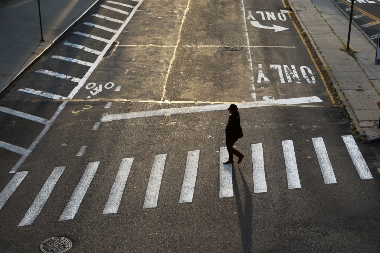 A woman crossing an empty street in Dumbo, Brooklyn, New York City, USA