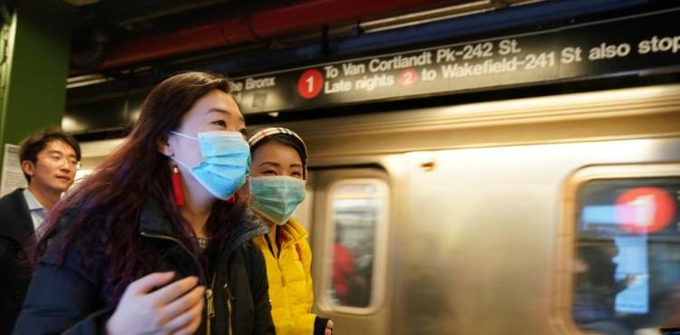 FILE PHOTO: People wear surgical masks in the subway station at Times Square in New York, U.S., January 31, 2020.