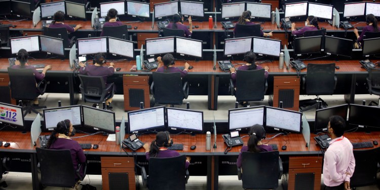Employees wearing protective masks work inside a call centre run by Uttar Pradesh state police during an extended lockdown to slow the spreading of coronavirus disease (COVID-19) in Lucknow, India