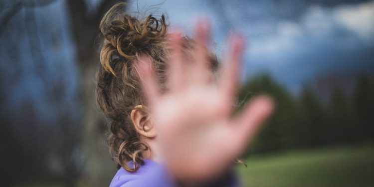 Girl blocks camera with her hand