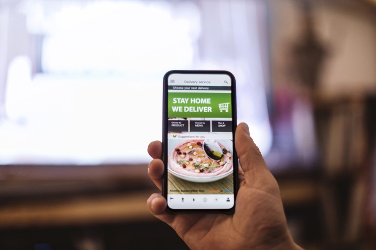 Person holding phone, showing food-ordering app