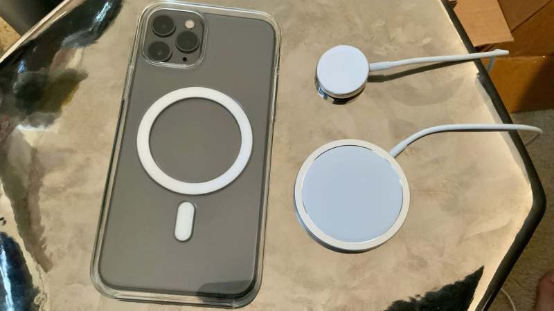 Apple's MagSafe Charger for the iPhone shown alongside the Apple Watch Magnetic Charging Cable and an MagSafe clear case.