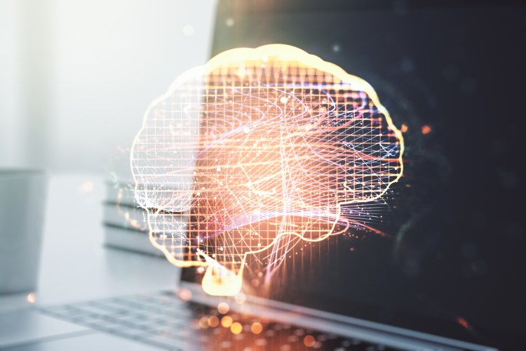 a digital brain projected over a laptop