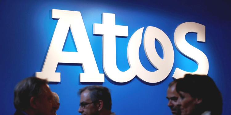 People walk in front of Atos company's logo during a presentation of the new Bull sequana supercomputer in Paris, France, April 12, 2016. 
