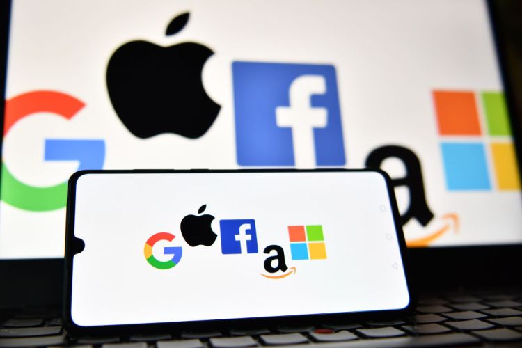 An illustration picture taken in London on December 18, 2020 shows the logos of Google, Apple, Facebook, Amazon and Microsoft displayed on a mobile phone and a laptop screen. (Photo by JUSTIN TALLIS / AFP) (Photo by JUSTIN TALLIS/AFP via Getty Images)
