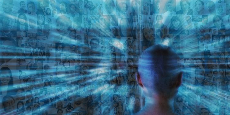 Hundreds of social media portraits zoom past a futuristic person monitoring the crowd.