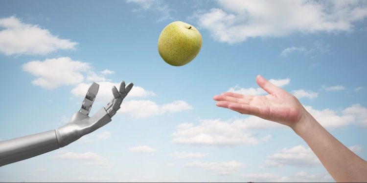 Artificial intelligence passing a green apple to a human hand.