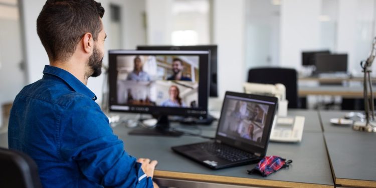 Remote worker doing a business teleconference in an office setting.
