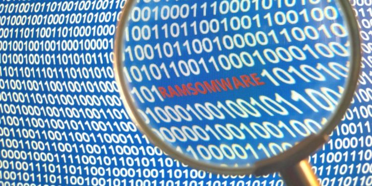 Image of magnifying glass looking at the word RANSOMWARE written on a computer screen